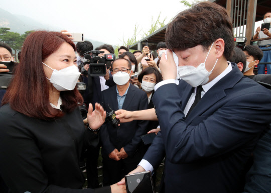 국민의힘 이준석 신임 대표가 14일 오전 대전시 유성구 갑동 국립대전현충원 천안함 46용사 묘역에서 희생자 유족을 만나 눈물을 흘리고 있다. <연합뉴스>